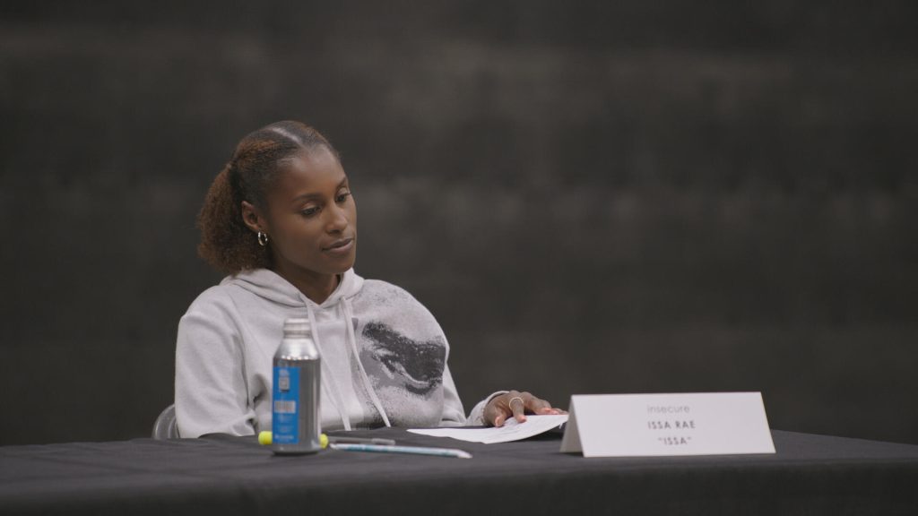 A behind-the-scenes image of Issa Rae at a table reading for the TV show, Insecure.