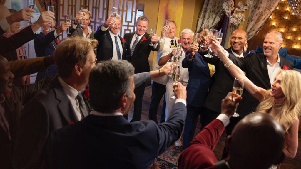 A still image of the cast of The Golden Bachelorette cheering with champagne. 